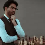 Serious ethnic man thinking over tactic of playing chess