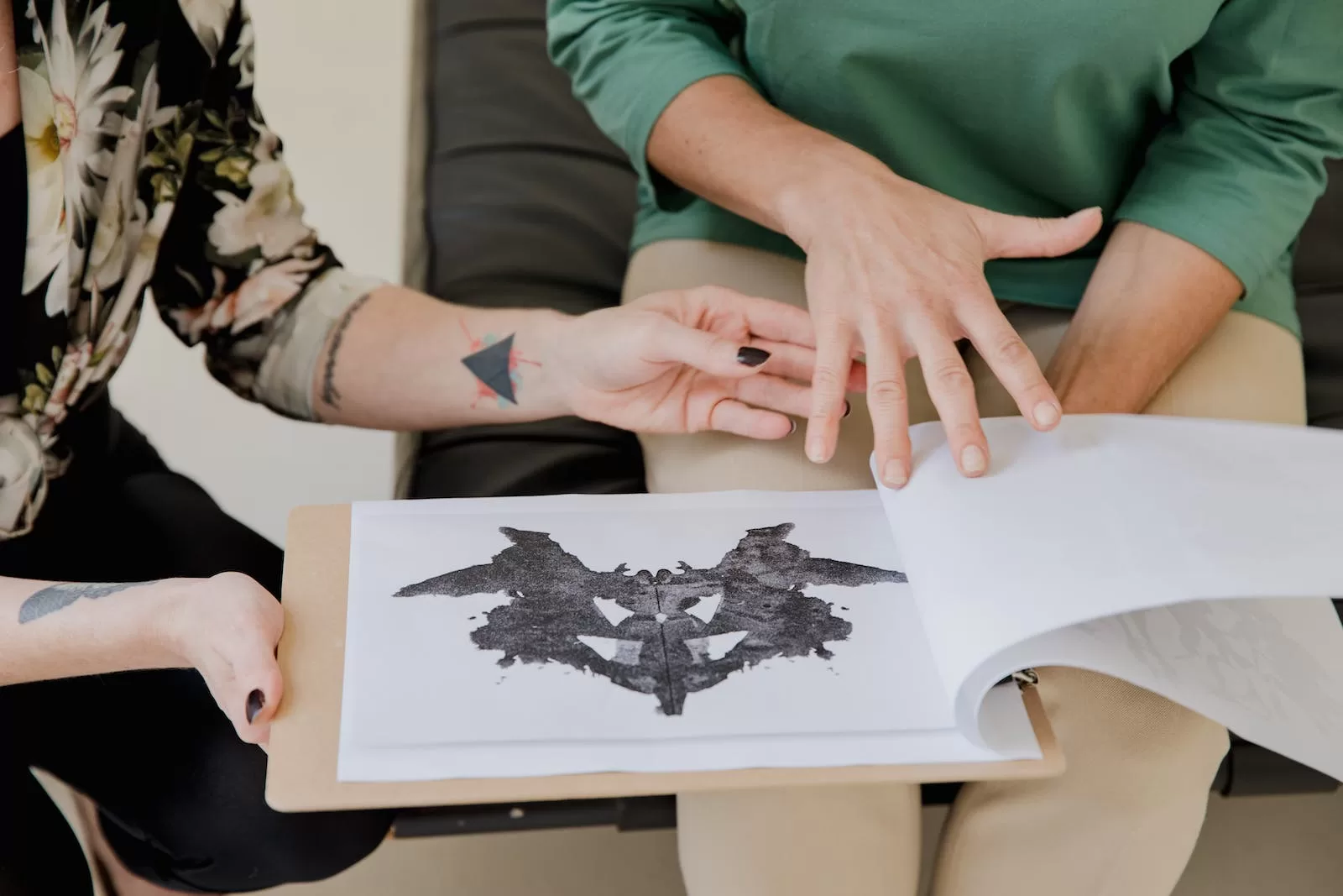 Person in Green Shirt Holding Pictures of Rorschach Test